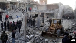 People gather around destroyed buildings after airstrikes hit areas in Aleppo, Syria, January 14, 2013.