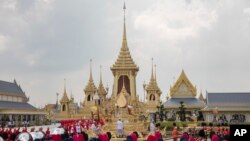 The ceremonial urn of Thailand's late King Bhumibol Adulyadej arrives at the crematorium during the funeral procession as royal crematorium is seen in the background in Bangkok, Thailand, Oct. 26, 2017.