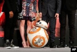 BB-8 droid poses with actors and director during a press conference for their latest film "Star Wars: The Force Awakens" at a hotel in Urayasu, near Tokyo, Dec. 11, 2015.