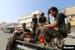 FILE - Houthi militants patrol a street where pro-Houthi protesters demonstrated against the Saudi-led coalition in Hodeidah, Yemen.