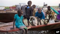 Children cautiously disembark from a boat that has carried them across the Nile to a village in Awerial, which has received tens of thousands of people who fled fighting in Bor, Jonglei state.