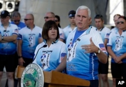 FILE - Indiana Gov. Mike Pence speaks as his wife, Karen, looks on at the opening ceremony for the Cops Cycling for Survivors fundraising bike ride in Indianapolis, July 11, 2016.