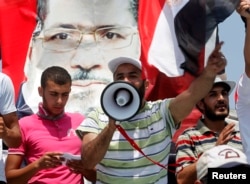 Supporters of ousted President Mohamed Mursi shout slogans as they attend weekly Friday prayers at Rabaa Adawiya square, where they are camping, in Cairo July 12, 2013