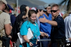 An officer directs people at the main entrance of Princes Juliana International Airport in Phillipsburg, where U.S. Air force units are to evacuate several hundreds of American citizens, after the passage of Hurricane Irma, in St. Martin, Sept. 11, 20