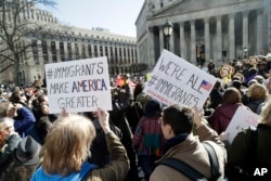 People hold anti-deportation signs during a rally, March 9, 2017, in New York. The rally was held in support of Ravi Ragbir, leader of the New Sanctuary Coalition, and an immigrant from Trinidad, who may face deportation.