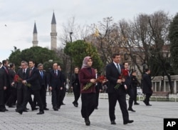 Turkey's Prime Minister Ahmet Davutoglu, right, accompanied by his wife Sare, visit the site of Tuesday's explosion, in the historic Sultanahmet district of Istanbul, Wednesday, Jan. 13, 2016.