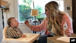 Jocelyn Smith cares for her 11-month-old son, Mason at their home in Camas, Wash., Jan. 30, 2019. Smith has been afraid to take Mason out of the house during a measles outbreak in southwest Washington because he is too young to receive the measles vaccine.