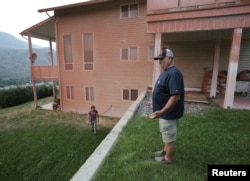 Fred Gerwien (R) and his son Wes Gerwien arrive back at their family home that was covered in fire retardant in Cache Creek, British Columbia, Canada, July 18, 2017.