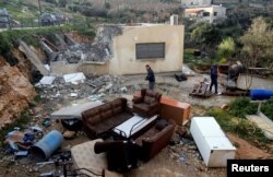 Palestinians check the damage after Israeli forces demolished a house in the village of Al-Walaja near Bethlehem, in the Israeli-occupied West Bank, Feb. 11, 2019.