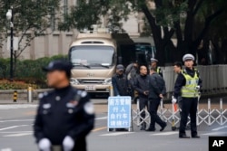 Policemen and security personnel stand guard on a closed road at the entrance to the Jingxi hotel where Communist Party Central Committee members gathered in Beijing, China, Oct. 24, 2016.