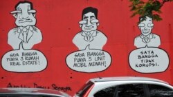 Sebuah mural bertuliskan "Saya Bangga Punya Tiga Rumah Mewah (Kiri), Saya Bangga Punya Lima Mobil Mewah (tengah), Saya Bangga Tidak Melakukan Korupsi", di dinding sebuah jalanan di Jakarta pada tanggal 18 November 2009. (Foto: AFP/Adek Berry)