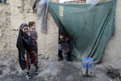 Seorang anak laki-laki pengungsi mengintip dari hunian sementara di Kota Kabul, Afghanistan, 30 Desember 2020.