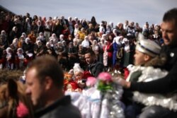 Seorang pria Muslim Bulgaria menggendong putranya di atas kuda saat mereka menghadiri ritual menjelang upacara khitanan massal di Desa Ribnovo, Bulgaria, 23 Februari 2020. (Foto: REUTERS/Stoyan Nenov)