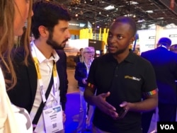 Alain Nteff's (R) startup helps deliver health information to pregnant women and new mothers. (VOA/ L. Bryant)