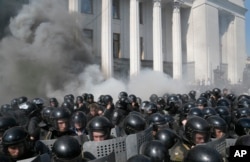 Smoke rises outside Ukraine's parliament building as riot police clash with nationalist protesters, in Kyiv, Aug. 31, 2015.