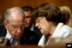 FILE - Senate Judiciary Committee Chairman Chuck Grassley, R-Iowa, talks with the committee's ranking member, Sen. Dianne Feinstein, D-California, on Capitol Hill in Washington, July 12, 2017.