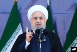 Iran's President Hassan Rouhani speaks at a military parade marking the 38th anniversary of Iraq's 1980 invasion of Iran, in front of the shrine of the late revolutionary founder, Ayatollah Khomeini, outside Tehran, Iran, Saturday, Sept. 22, 2018.