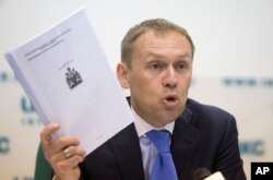 Andrei Lugovoi holds papers he which he said he got from Scotland Yard, during press conference in Moscow, Russia, March 12, 2013, about the 2006 poisoning of former Russian agent turned Kremlin critic Alexander Litvinenko in London.
