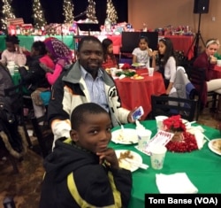 Akembe Bilombele, center, fled war-torn Congo with his family and was resettled in Twin Falls, Idaho, four months ago. "People in Idaho are very kind," he said at a church Christmas party. "I am very happy here."