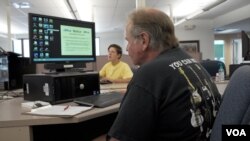 Custodial worker Glenn Hendrickson studies job openings at CareerLink, the PA employment office. He is not interested in farm work. (M. Kornely/VOA)