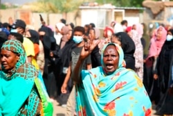 A pro-democracy protester flashes the victory sign as thousands take to the streets to condemn a takeover by military officials, in Khartoum, Sudan, Oct. 25, 2021.