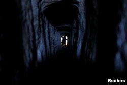 A figure is seen inside one of two manmade tunnels excavated by Hebrew University archaeologist Oren Gutfeld in the Judean desert near the Qumran area in the Israeli-occupied West Bank October 14, 2018. (REUTERS/Ronen Zvulun)