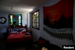 Solange, a worker at Pousada Favelinha (Little favela) hostel, prepares a room in Pereira da Silva favela, in Rio de Janeiro, Brazil, April 21, 2016.