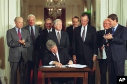 FILE - U.S. President Bill Clinton signs a side deal of the three-nation North American Free Trade Agreement (NAFTA) at the White House, Washington, D.C., Sept. 14, 1993.
