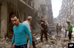 FILE - Image made from video and posted online from Validated UGC, a man carries a child after airstrikes hit Aleppo, Syria.