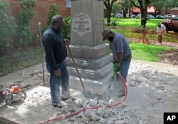 FILE - Workers begin removing a Confederate statue in Gainesivlle, Fla., Aug. 14, 2017. The statue is being returned to the local chapter of the United Daughters of the Confederacy, which erected the bronze statue in 1904.