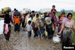 A group of Rohingya refugees walk on a muddy road after crossing the Myanmar-Bangladesh border in Teknaf, Bangladesh, Sept. 1, 2017.