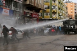 FILE - Turkish riot police use a water cannon to disperse Kurdish demonstrators during a protest against a curfew in Sur district and security operations in the region, in the southeastern city of Diyarbakir, Turkey, Jan. 17, 2016.