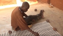 An artisan paints textiles in Mali’s capital, Bamako. Mali was suspended Jan. 1 from a trade program giving duty-free access to U.S. markets. (Moctar Barry/VOA)