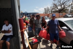People queue at a gas station to fill up their fuel containers, after the island was hit by Hurricane Maria, in San Juan, Puerto Rico, Sept. 28, 2017.