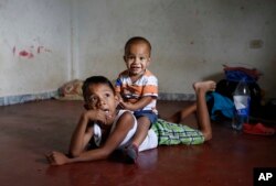 En esta foto del 27 de junio de 2018, los niños migrantes venezolanos juegan en el piso de la casa sin muebles que sus padres están alquilando y compartiendo durante los últimos dos años con otra familia venezolana en Cúcuta, Colombia.