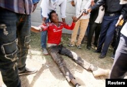 People assist an injured protestor during Irrechaa, the thanks giving festival of the Oromo people in Bishoftu town of Oromia region, Ethiopia, October 2, 2016.