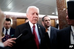 Senate Health, Education, Labor and Pensions Committee member Sen. Orrin Hatch, center, leaves the committee's executive session on Education Secretary-designate Betsy DeVos, on Capitol Hill in Washington, Jan. 31, 2017.