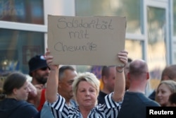 Demonstrators hold banners during a protest in Cologne, Germany, Aug. 28, 2018. The banner reads, "Solidarity with Chemnitz."
