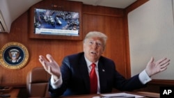 President Donald Trump, on board Air Force One, gestures while watching a live television broadcast of the Senate confirmation vote of Supreme Court nominee Brett Kavanaugh, Oct. 6, 2018. Trump was traveling from Washington to Topeka, Kan., for a campaign rally.