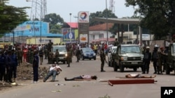 FILE - Bodies of people killed during election protests lie in the street as Congolese troops stand by in Kinshasa, Democratic Republic of Congo, Sept. 19, 2016. More than 50 people died during protests in September, according to rights groups and the United Nations.