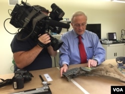 Joe Reynolds, CEO of RTI Group LLC. examines structural plane parts for thermal damage, Aug. 11, 2015. (Photo: Carolyn Presutti / VOA)