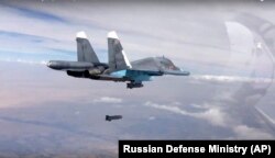 FILE - A bomb is released from Russian Su-34 strike fighter in Syria, Oct. 9, 2015.