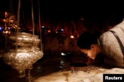 A worshipper kisses the star inside the cave at the Church of the Nativity, in Bethlehem in the Israeli-occupied West Bank, Dec. 23, 2018.
