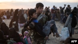 A wounded child is evacuated from the Islamic State group's embattled holdout of Baghuz and upon arriving at a screening area held by the U.S.-backed Kurdish-led Syrian Democratic Forces, in northeastern Syria, March 6, 2019.