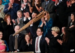 FILE - Ji Seong-ho holds up his crutches after being acknowledged by President Donald Trump during Trump's address to a joint session of Congress on Capitol Hill in Washington, Jan. 30, 2018.