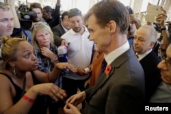 The British Ambassador to Egypt, John Casson, talks to British tourists after the announcement by easyJet staff that there would not be any more flights today to evacuate tourists from Sharm el-Sheikh, south Sinai, Egypt, Nov. 6, 2015.