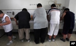 FILE - In this July 24, 2008, file photo, obese patients wash their plates after lunch at the Aimin Fat Reduction Hospital in Tianjin, China. A study released at that time said China had surpassed some richer countries long plagued with diabetes to develop the world's biggest epidemic.