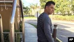 FILE - Luis Alberto Rodriguez, 43, waits for a friend to pick him up from temporary housing in Miami, Jan. 13, 2017.