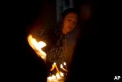 A Christian woman prays in the Church of the Holy Sepulchre, traditionally believed by many to be the site of the crucifixion of Jesus Christ, during the Holy Week procession in Jerusalem's Old City, April 20, 2019.