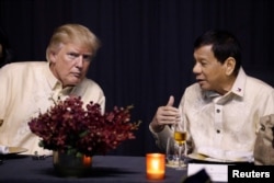 U.S. President Donald Trump talks with Philippines President Rodrigo Duterte during the gala dinner marking ASEAN's 50th anniversary in Manila, Philippines, Nov. 12, 2017.